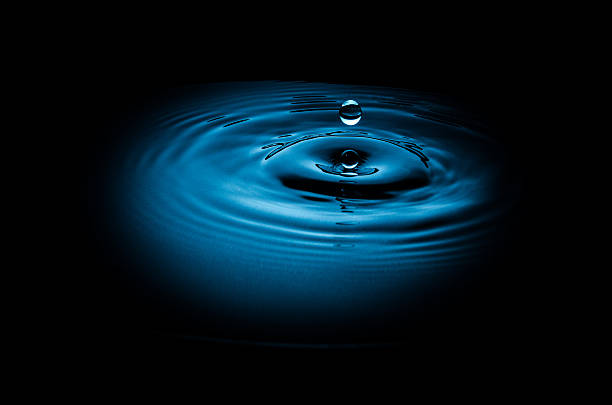 istock Drop of water falling into blue abstract black background 181963477
