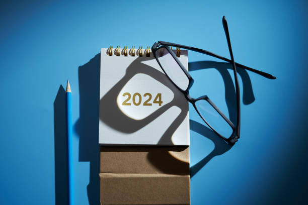 istock eyeglasses rest on the 2024 desk calendar against blue background 1819646111