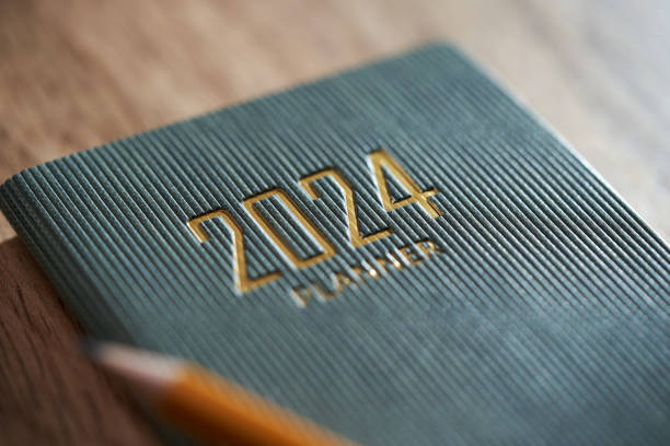 2024 planner and yellow pencil on wood background