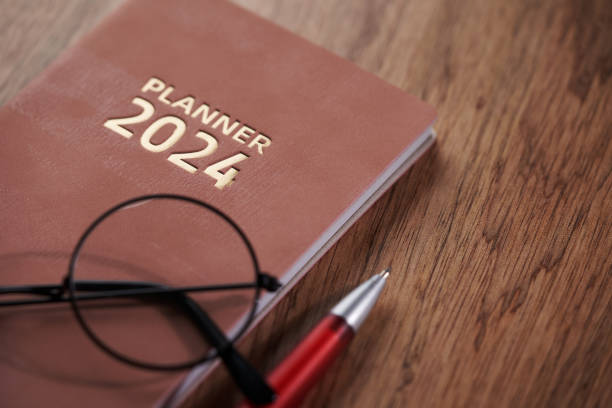 istock 2024 planner with pen on wooden table top 1819652355