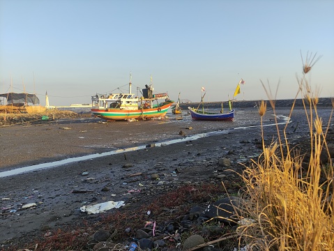A boat stranded near the harbor due to low tide, , on Paiton Beach, East Java, Indonesia