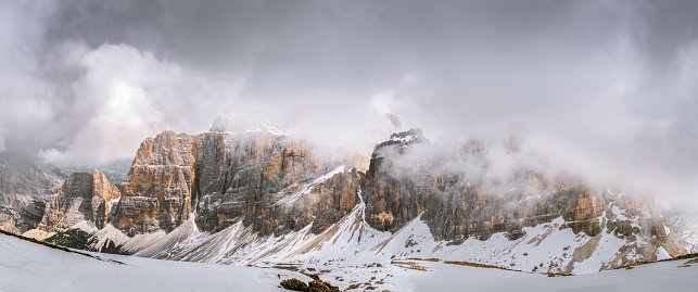 View of snowcapped mountain range in the Dolomites, Italy, on cloudy day