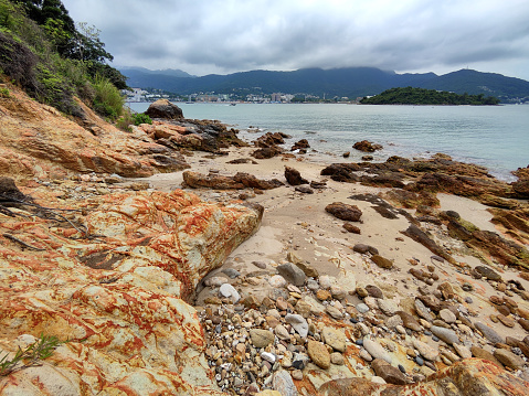 Ancient rocks on the coast at Pak Sha Chau, a small island with tombolo off Sai Kung town coast, Hong Kong.