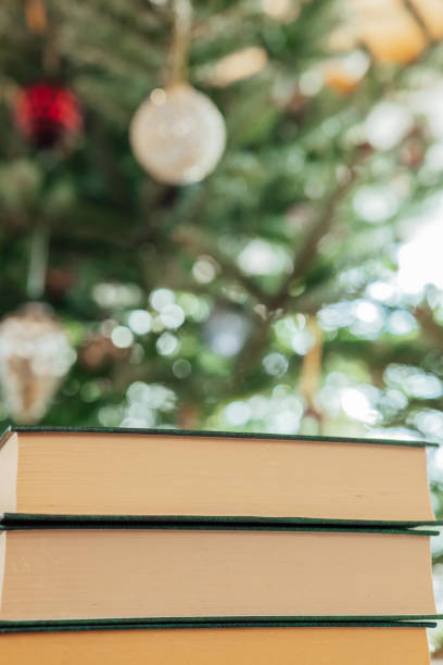istock Christmas books. books with green covers stack on Christmas tree background.Cozy mood. Winter Season books. Books on Christmas and winter themes.Christmas tales. Education during the winter holidays. 1819669938