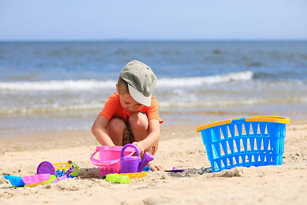istock boy playing toys on beach 181971213