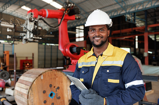 Portrait African-American engineer man holding tablet and smile in factory