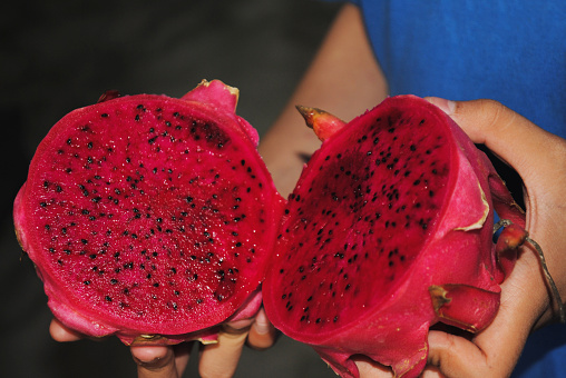 Half of Australian Dragon fruit with red flesh, white background with copy space, full frame horizontal composition