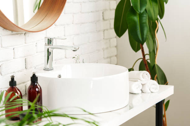 istock Bathroom interior with circle shaped mirror in wooden frame and white sink 1819800383