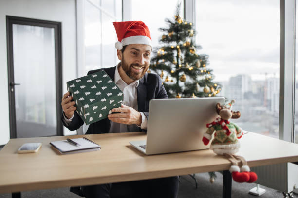 istock Caucasian man in Santa hat unpacking Christmas gift. 1819812563