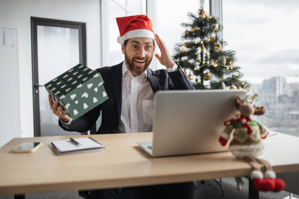 istock Caucasian man in Santa hat unpacking Christmas gift. 1819812566