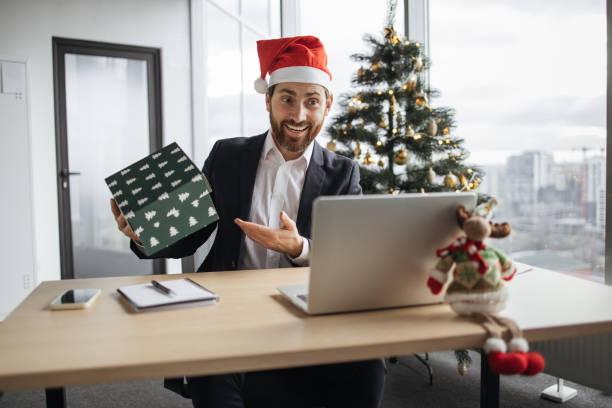 istock Caucasian man in Santa hat unpacking Christmas gift. 1819812568