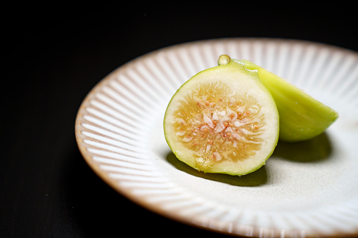 Fresh figs in bowl on rustic wooden background, high angle view