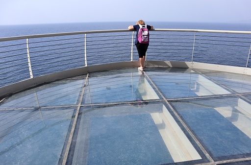 Maratea, Basilicata, Italy - September 23, 2023: Girl on the Sky walk, the panoramic terrace on Strada Statale 18 in Cersuta inaugurated on September 14, 2023, overlooking the Gulf of Policastro