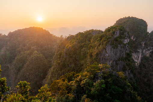 Scenic view of rainforest covered mountain range at sunset in Thailand