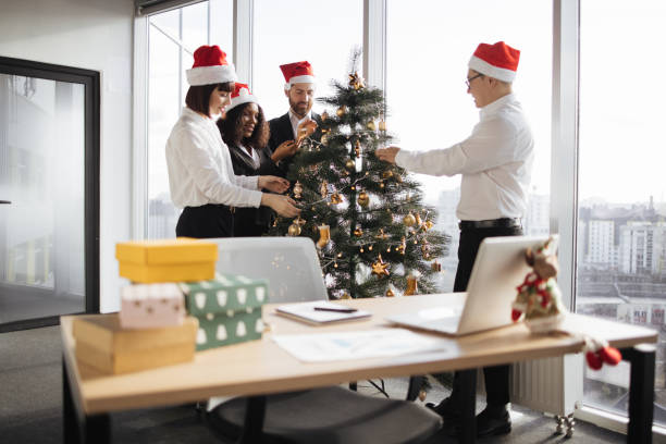 istock Multiethnic group of coworkers decorating christmas tree. 1819858474