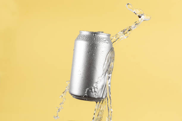 istock Aluminium beer or soda drinking can with water splash on light yellow background 1819863845
