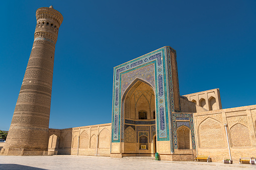 JUNE 27, 2023, BUKHARA, UZBEKISTAN: Awesome view of the Kalan Minaret of Po-i-Kalan complex in Bukhara, Uzbekistan. The ancient brick tower is a popular tourist attraction of Central Asia