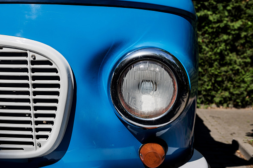 the headlight of a blue retro car. old-fashioned retro model auto