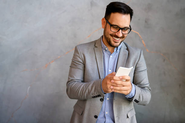 istock Handsome businessman checking emails on the phone in modern office in coffee break 1819892045