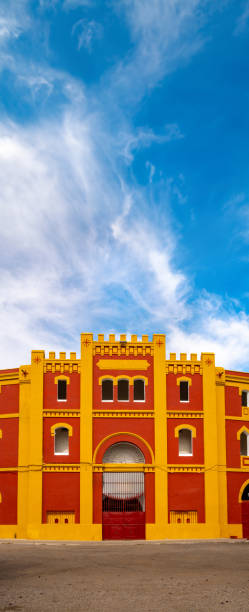 façade rouge et jaune des arènes de mérida, en estrémadure en espagne, sous un ciel bleu avec des nuages blancs. - maestranza bullring photos et images de collection