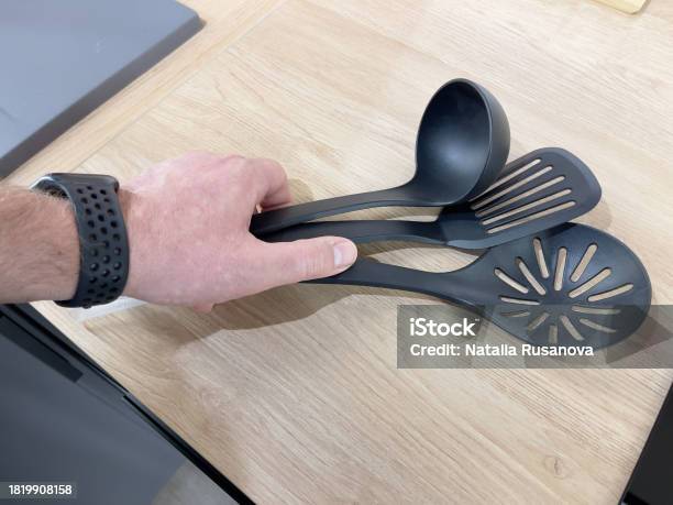 https://media.istockphoto.com/id/1819908158/photo/mans-hand-holding-black-kitchen-utensils-on-a-wooden-table.jpg?s=612x612&w=is&k=20&c=wAvmF76tqCmynjcxU1YFXwnDkfVb-bMV8NdW5zPmDK4=