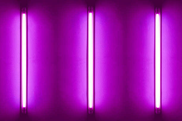 istock Three purple neon bulbs on white wall. Background texture of empty old wall with glowing purple neon bulbs. 1819908671