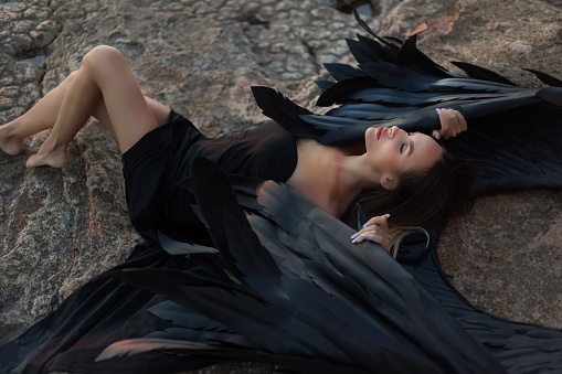 black angel lies on the seashore.fallen angel