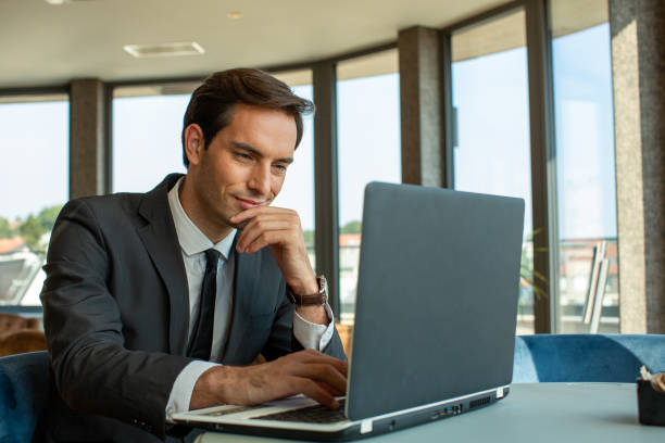 istock Handsome young businessman working on his notebook in hotel cafe 1819914480