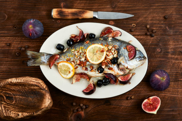 Baked dorado fish with almonds and figs. Autumn recipe grilled fish. Top view.