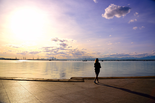 Silhouette of a girl standing by Guanabara Bay at sunset in Rio de Janeiro, Brazil.