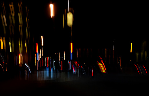 Traffic in London at night. Long exposure image with light trails from buses and cars beside Big Ben in Westminster, London, UK.  This is a deliberate blur using in camera movement (ICM) to create an abstract effect.