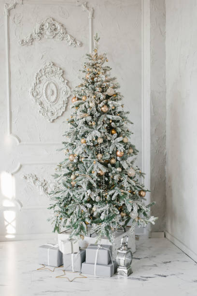 istock Silver Christmas tree with gifts under it in a classic interior 1819958920