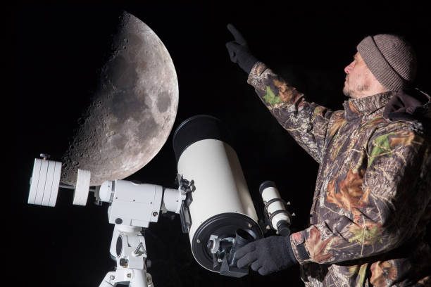istock man watching the moon through a telescope. 1819960542