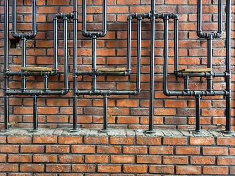 Metal pipes on red brick wall
