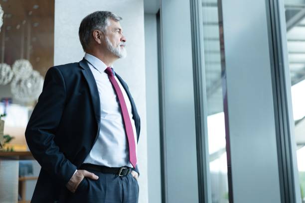 istock mature business leader senior manager standing by window, thinking 1820006258