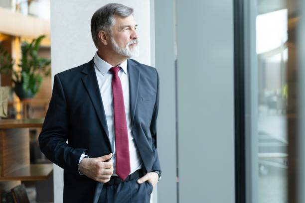 istock mature business leader senior manager standing by window, thinking 1820006262
