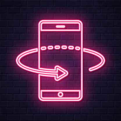 istock 360 degree rotation with smartphone. Glowing neon icon on brick wall background 1820015924
