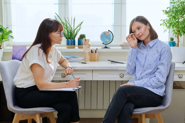 istock Sad stressed young woman in therapy with psychologist 1820015934