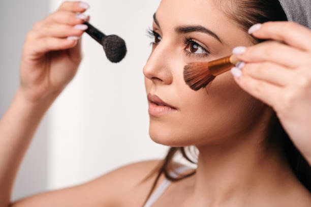 istock Gorgeous young woman with long hair smiling, posing, using makeup brushes 1820019748