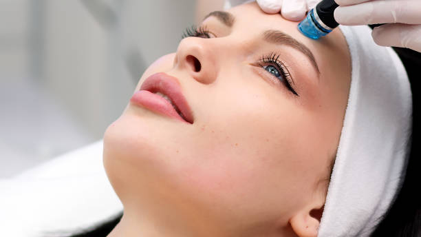 istock Professional dermatologist in medical gloves doing hydro peeling procedure for beautiful woman patient in cosmetology clinic. Close up facial treatment. 1820029621