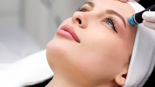 istock Professional dermatologist in medical gloves doing hydro peeling procedure for beautiful woman patient in cosmetology clinic. Close up facial treatment. 1820029630