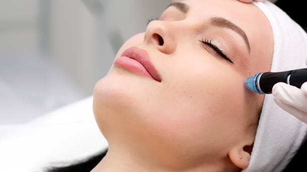 istock Professional dermatologist in medical gloves doing hydro peeling procedure for beautiful woman patient in cosmetology clinic. Close up facial treatment. 1820029643