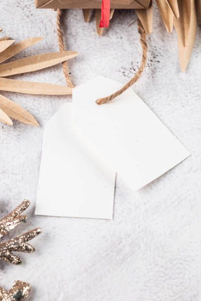 istock White blank paper tag or label with christmas gift box red Christmas decor on grey conkrete background. 1820033899