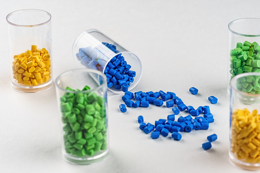 multi-colored plastic dye in granules in test tubes isolated on a white background.  Plastic factory laboratory. polymer industry.