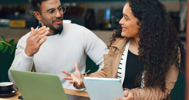 istock Coworkers, laptop and remote work with discussion, working and technology for business, strategy and plan. Cafe, meeting and brainstorming for project, woman and man in partnership, smile and job 1820068513