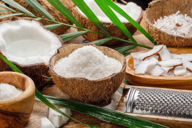 istock Fresh opened coconuts along with coconut slices, flakes and coconut leaves on a wooden table. Nice fruit background for your projects. 1820070828