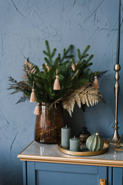 istock Fir branches with ornaments in a vase, Christmas tree decoration, candles on a blue wall background. Festively decorated Scandinavian room 1820079355