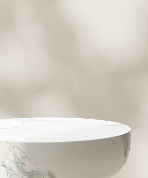 istock Close up modern round white marble side table podium in sunlight, leaf shadow on beige white wall 1820083597