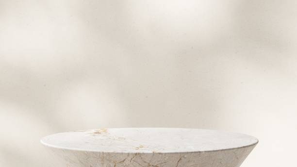 Close up modern round white marble side table podium in sunlight, leaf shadow on beige wall