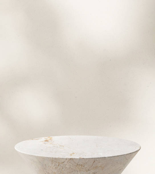 istock Close up modern round white marble side table podium in sunlight, leaf shadow on beige wall 1820084115